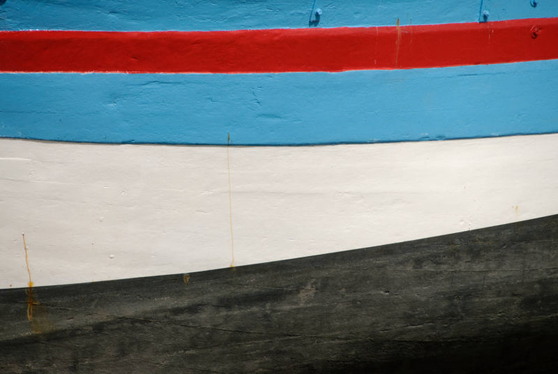 une coque de bateau quatre couleurs rouge bleu blanc et noir