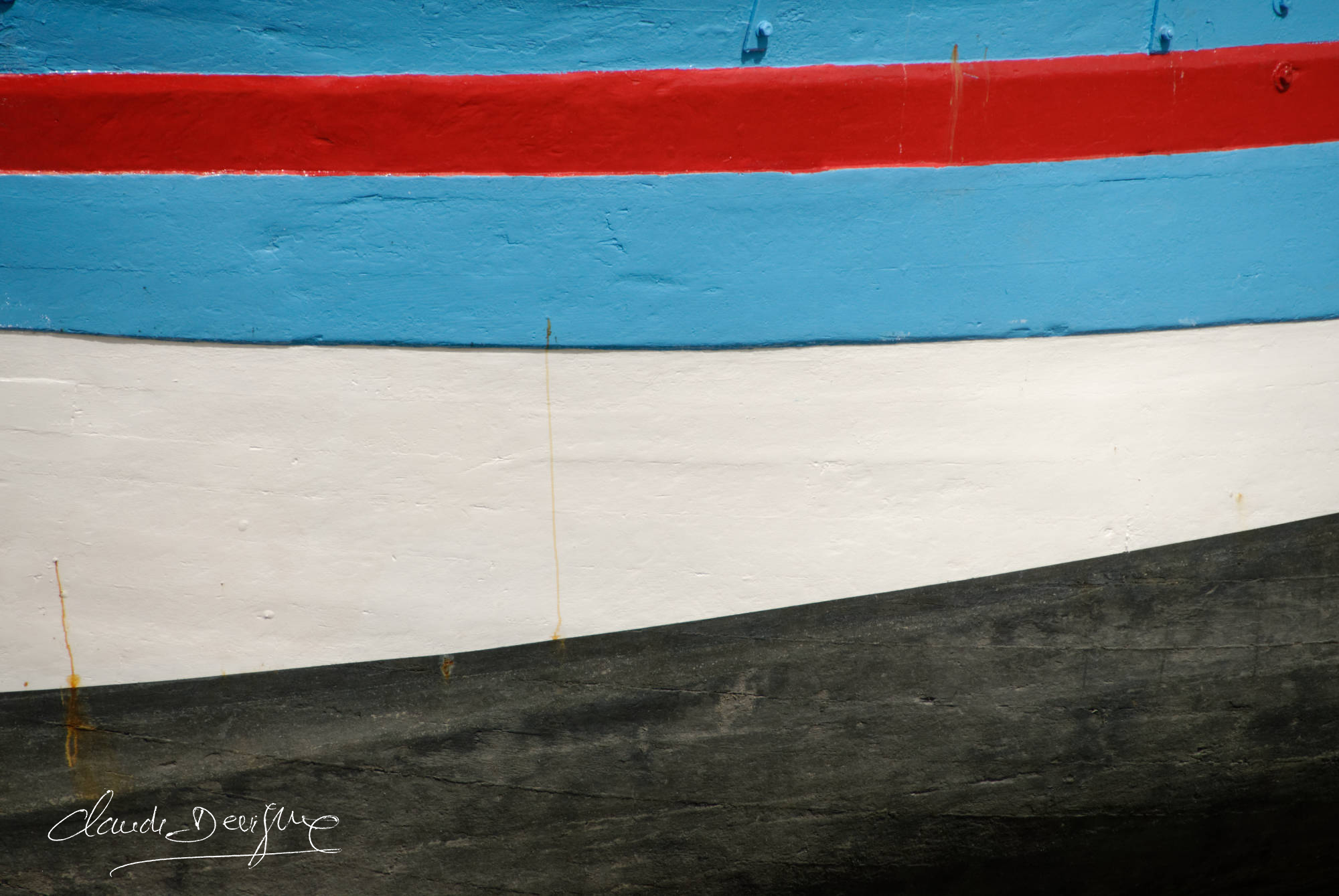 une coque de bateau quatre couleurs rouge bleu blanc et noir