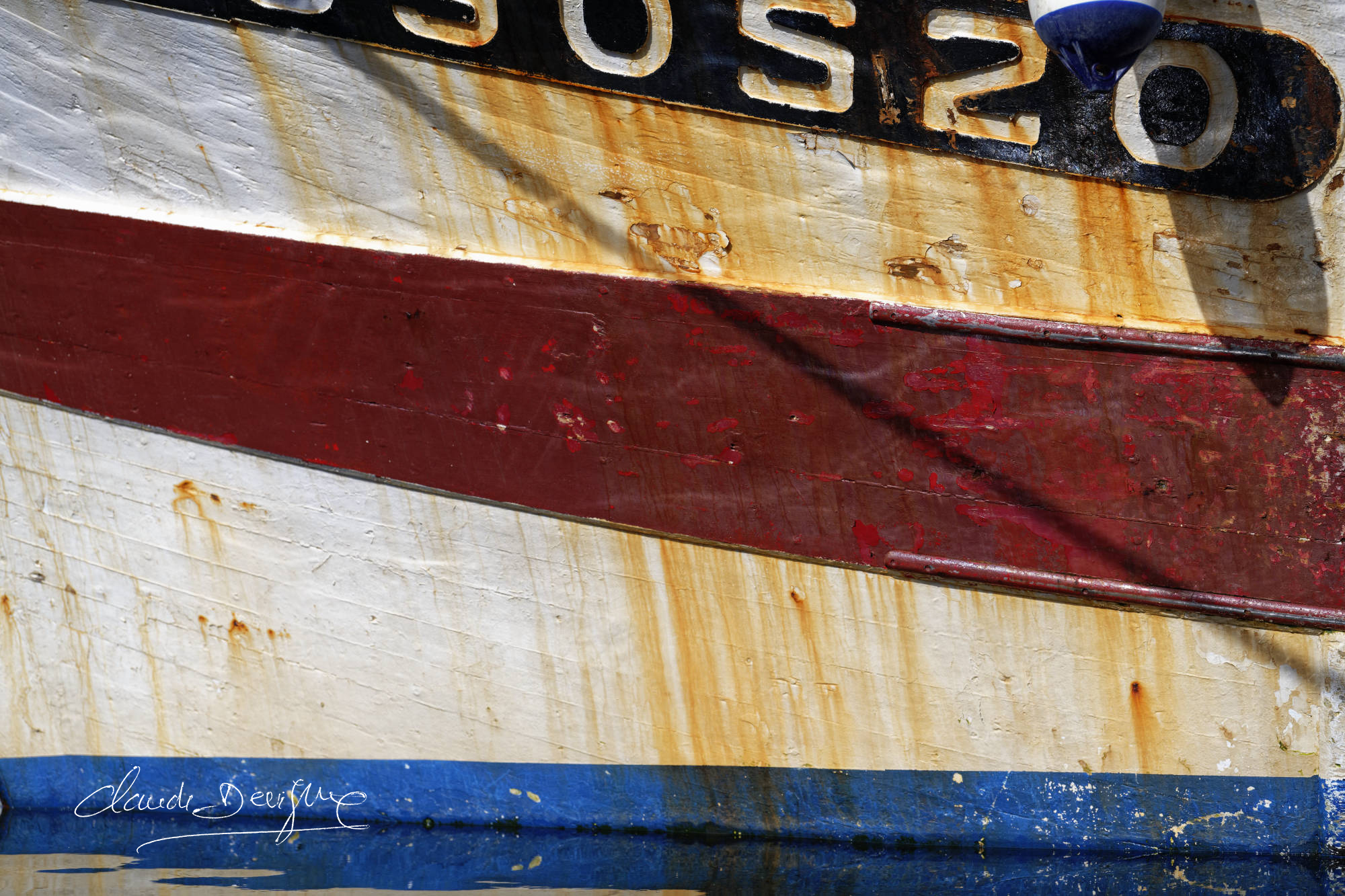 une coque de bateau trois couleurs bleu blanc rouge