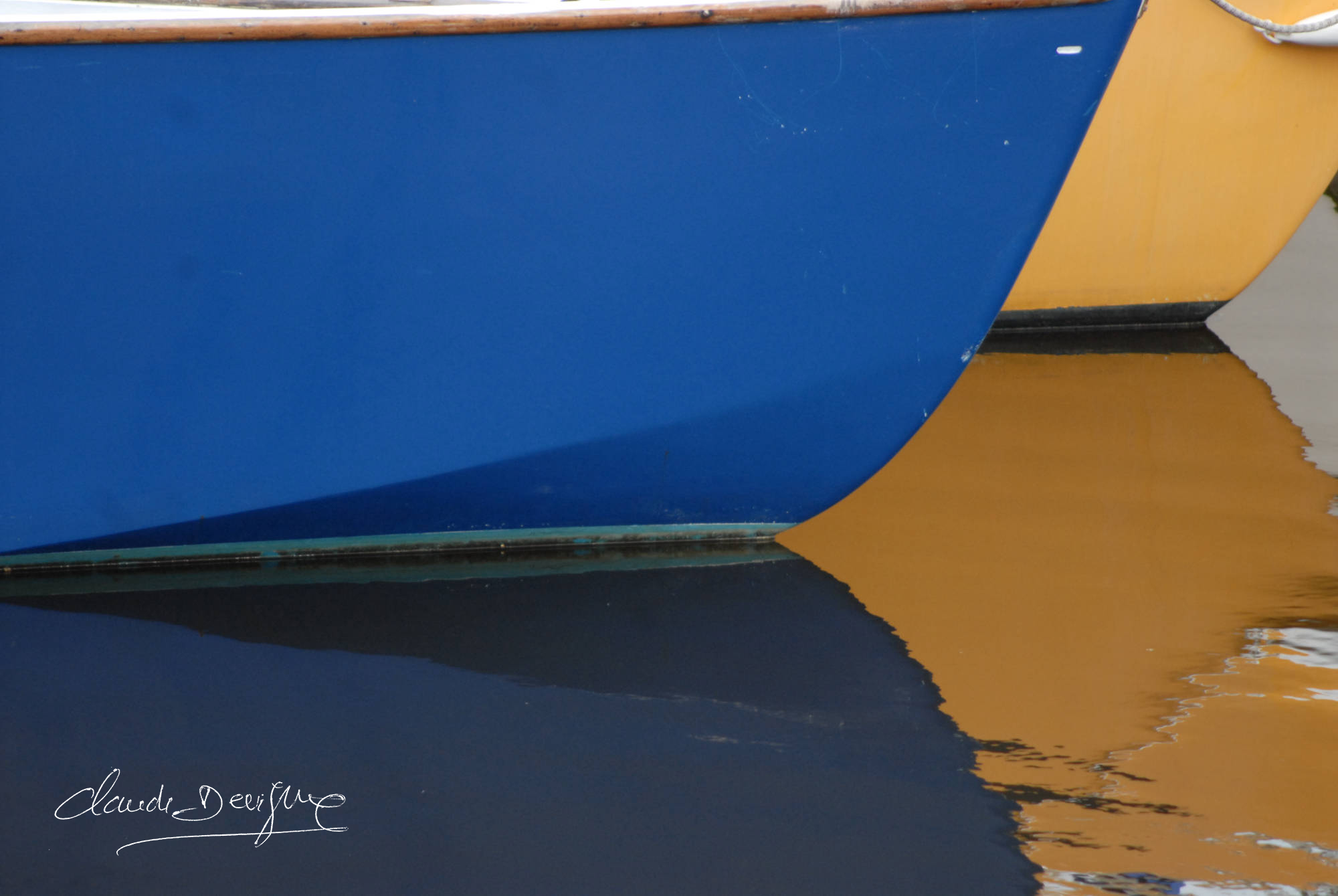 reflet de 2 coques de bâteau bleu et jaune